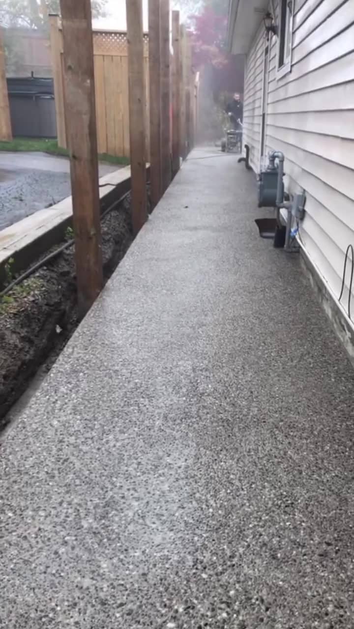 Exposed aggregate concrete walkway along the side of a house in Dundas